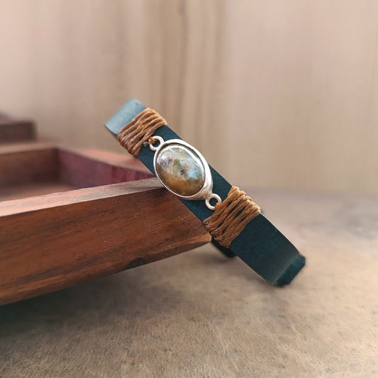 Jewelry with a stone and braided design on a wooden surface