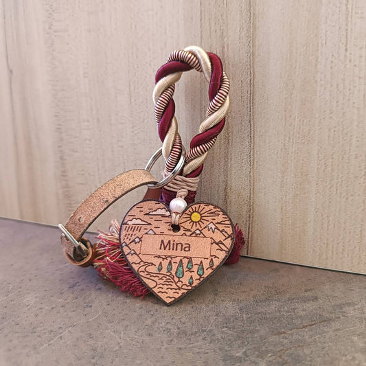 Heart-shaped keychain with 'Mina' engraving on a textured surface
