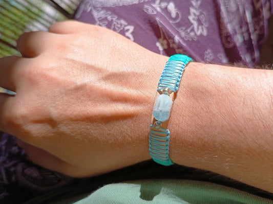 Ocean's Embrace Aquamarine & Crazy Horse leather bracelet, worn on woman's wrist. Handcrafted pale blue & seafoam green macrame.