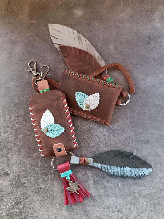 Brown leather keychain with feather designs on a gray surface