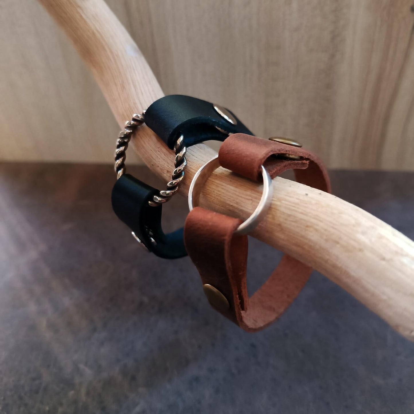 Full display of both the Black and Oak Brown minimalist ring holder bracelets side-by-side, emphasizing the available color contrast and the secure ring mechanism.