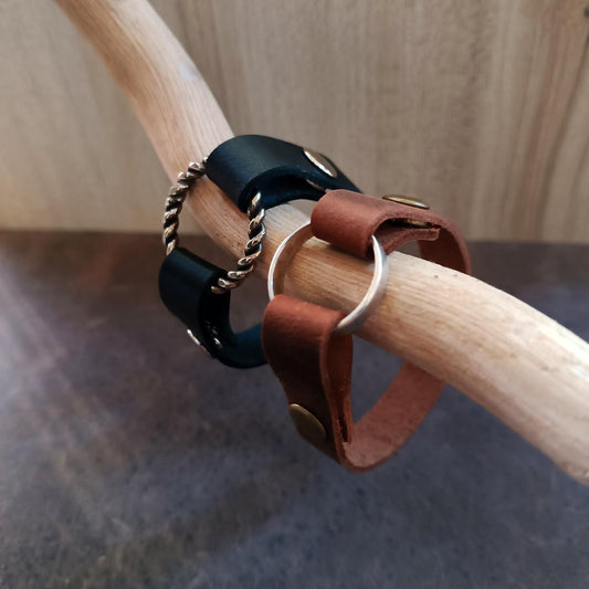 Full display of both the Black and Oak Brown minimalist ring holder bracelets side-by-side, emphasizing the available color contrast and the secure ring mechanism.