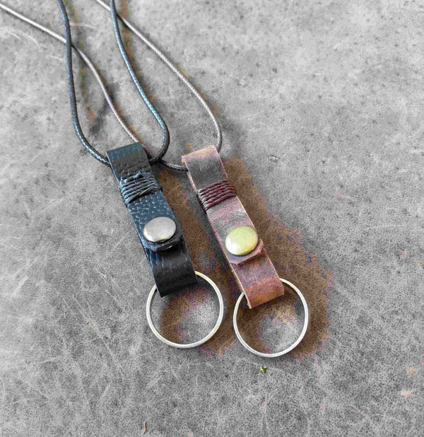 Two handmade leather ring holder pendants that carriy your ring close to your heart. Choose black or dark brown leather, with an optional matching adjustable cord.