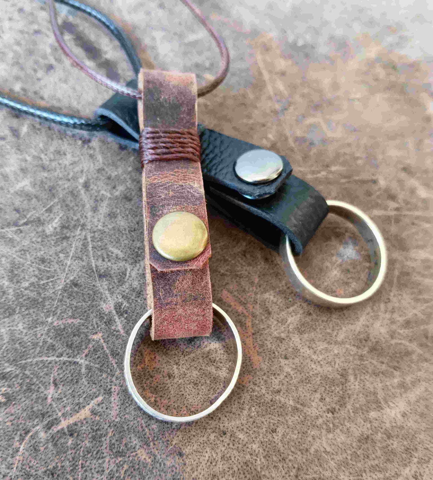 Two handmade leather ring holder pendants that carriy your ring close to your heart. Choose black or dark brown leather, with an optional matching adjustable cord.