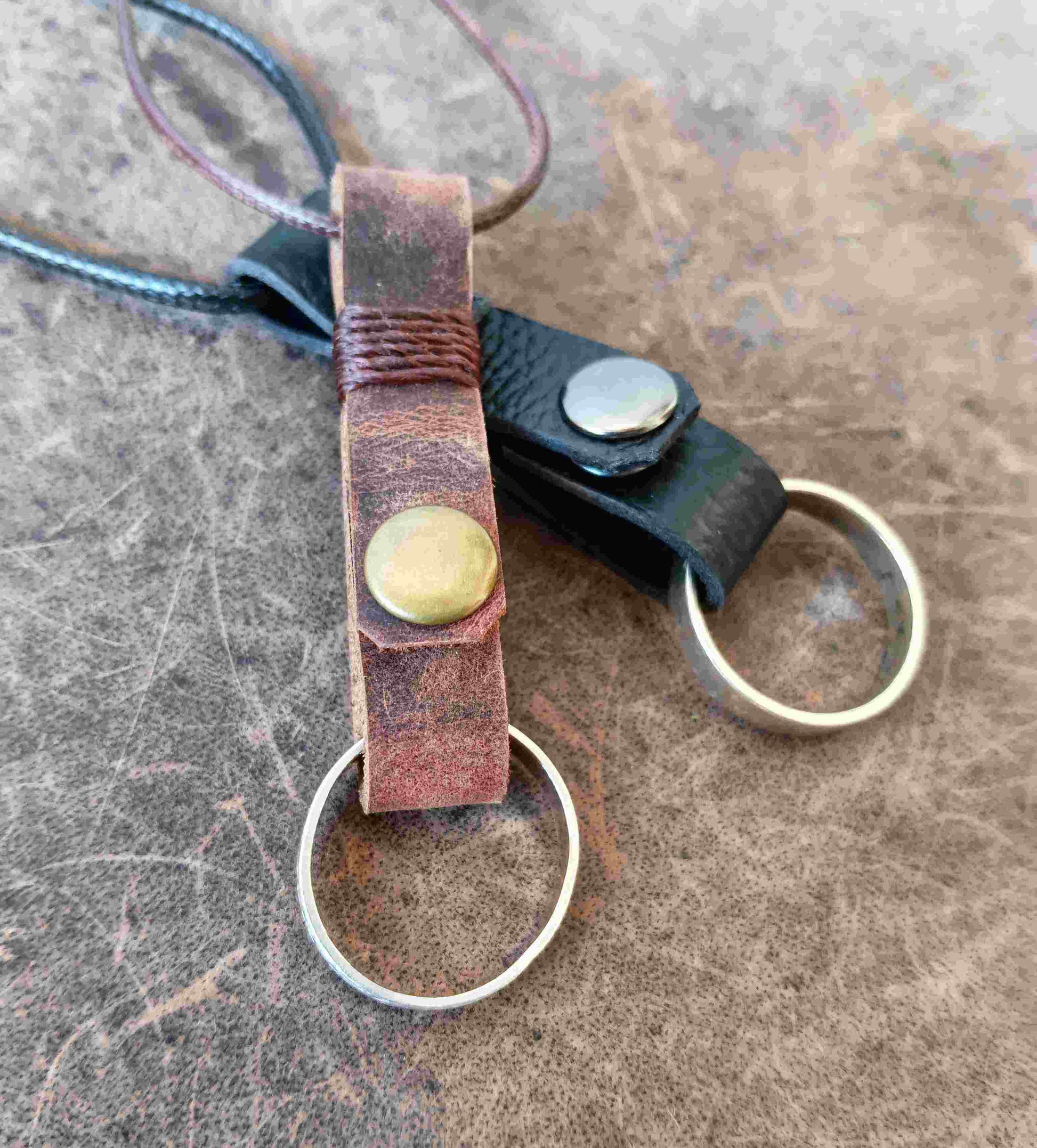Two handmade leather ring holder pendants that carriy your ring close to your heart. Choose black or dark brown leather, with an optional matching adjustable cord.