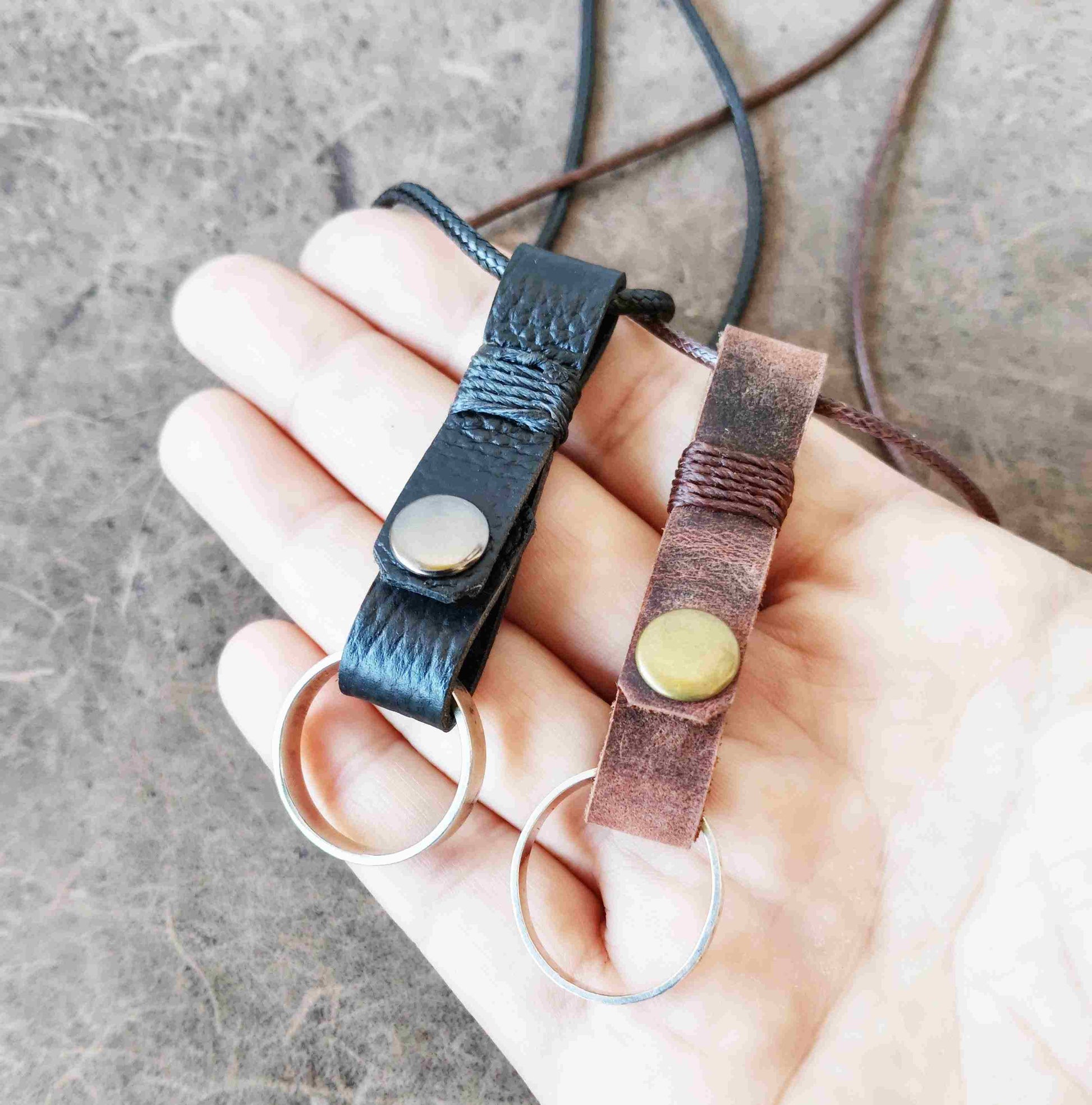 Two handmade leather ring holder pendants that carriy your ring close to your heart. Choose black or dark brown leather, with an optional matching adjustable cord.