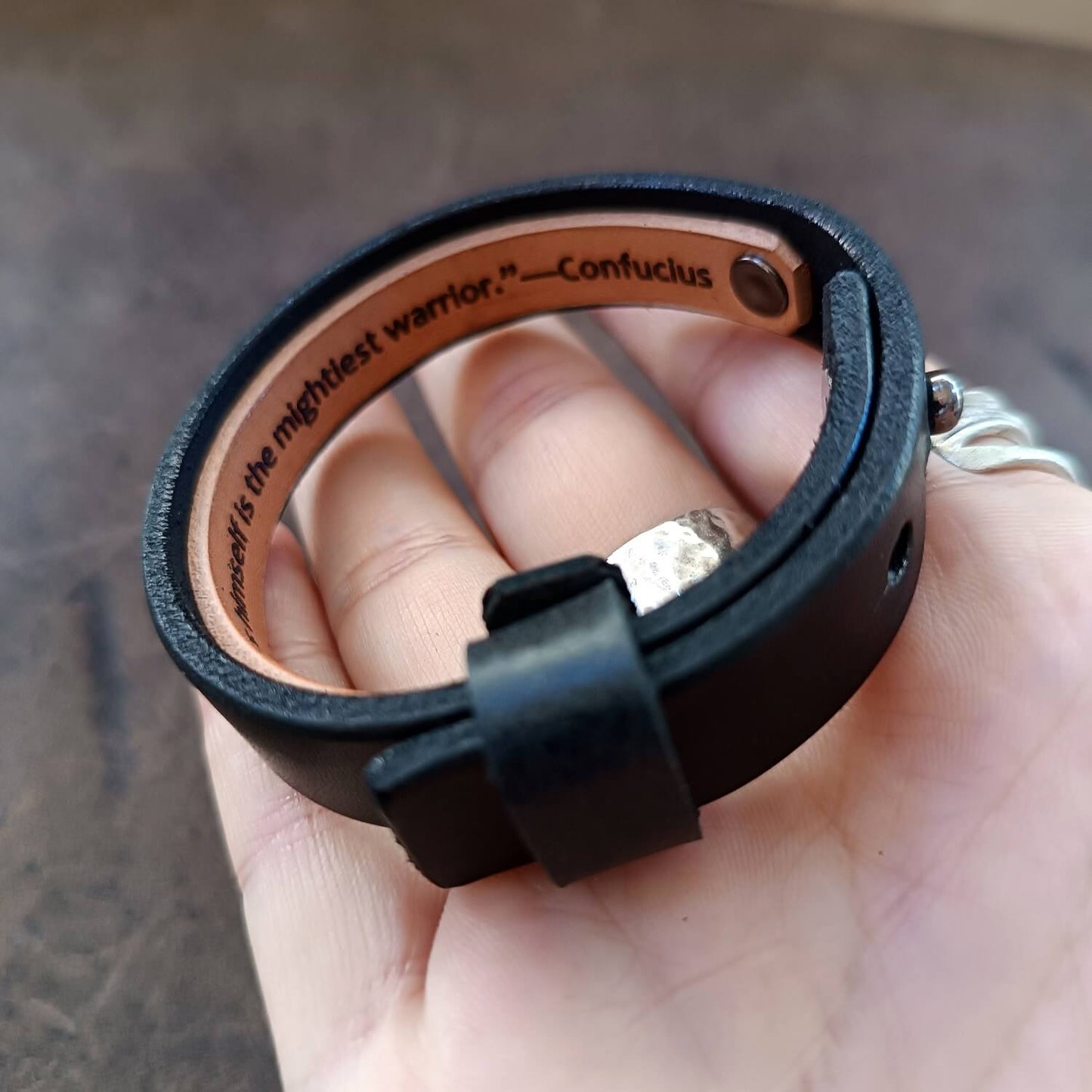 sample engraving of a long message on the underside of the black watchband style wristband, showcasing visibility