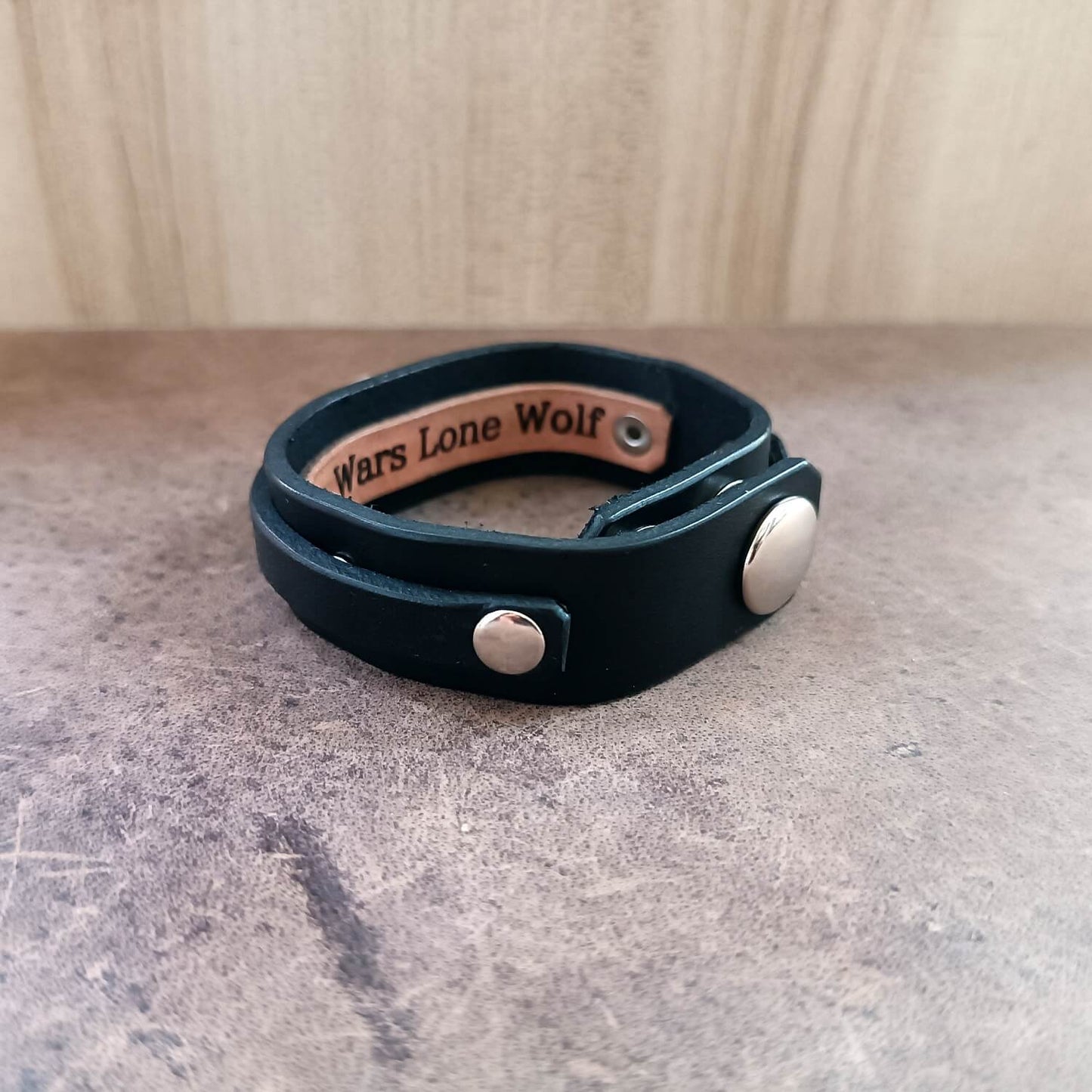 black leather cuff with silver wolf underside area for engraving