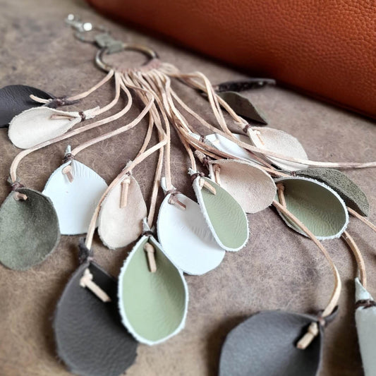 The extra-long Winter Whispers Charm close up, showcasing the different textures and colors of leather leaves