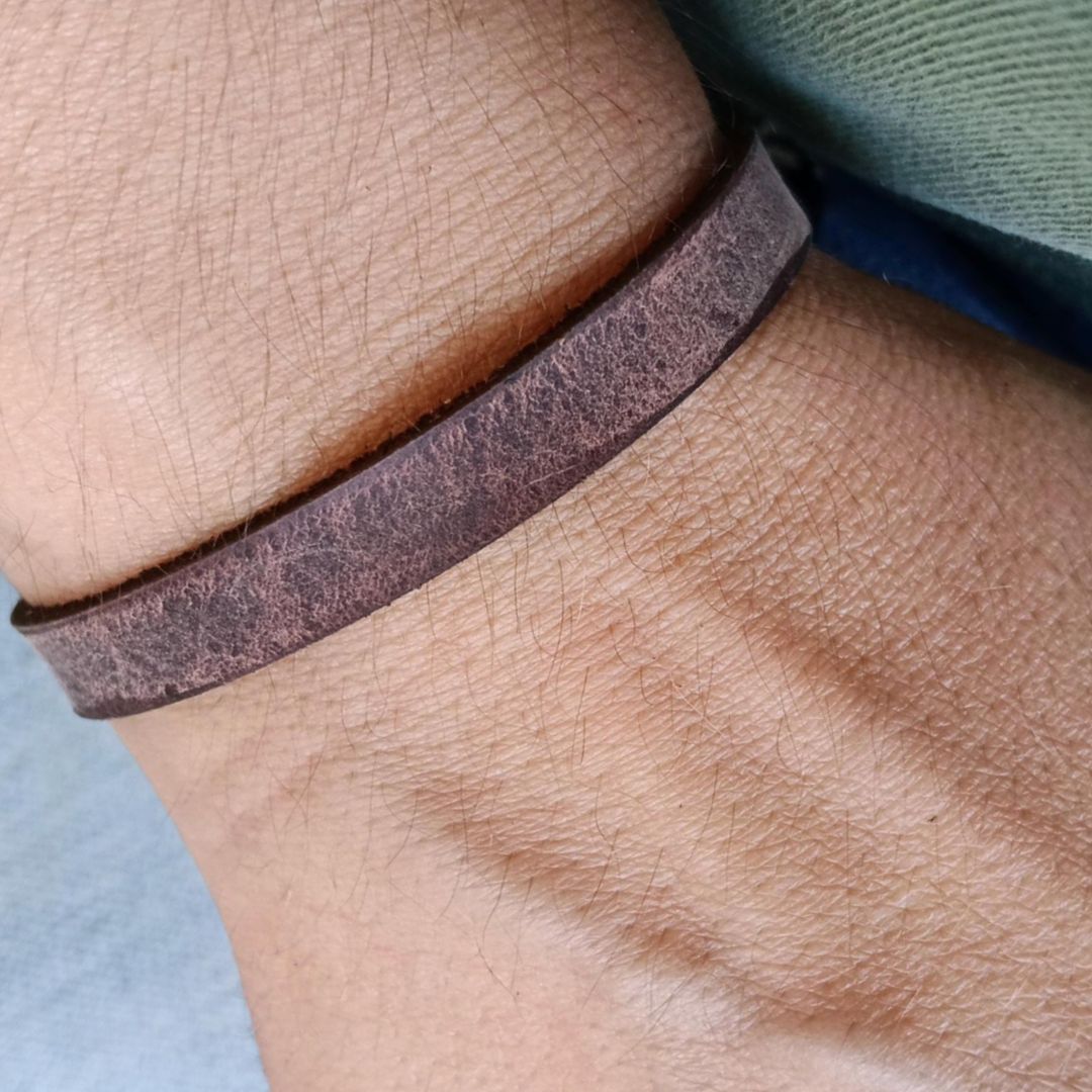close up view of the thin brown band worrn on wrist