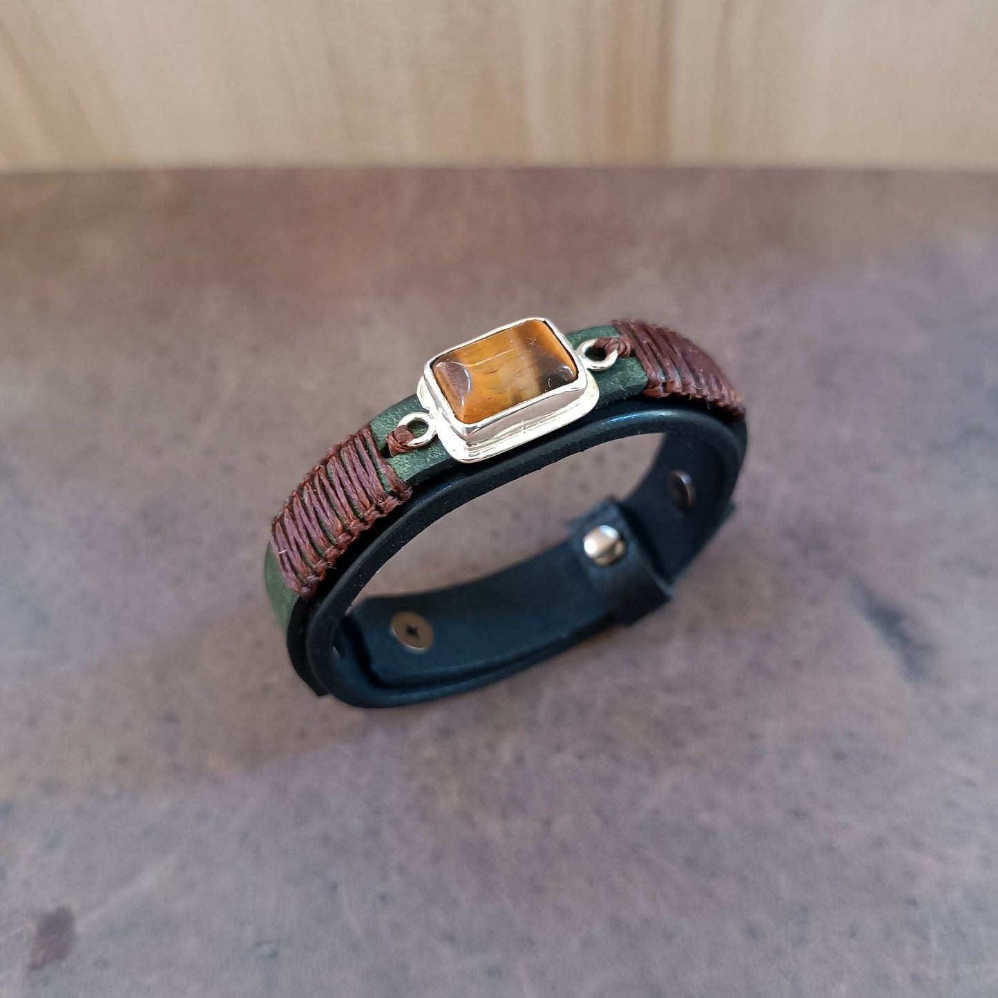 The Premium Black Oiled Vachetta Leather Bracelet with the khaki crazy horse top layer, sleek brown macrame and a solid sterling silver pendant with a hand cut Tiger's Eye stone.