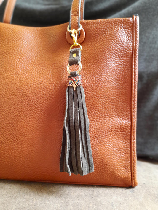 Tree of Life bag charm with olive green suede tassel and colorful rhinestone pendant.