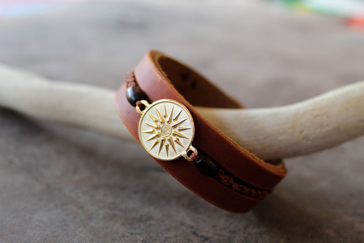 handmade brown leather cuff bracelet featuring a vergina sun pendant