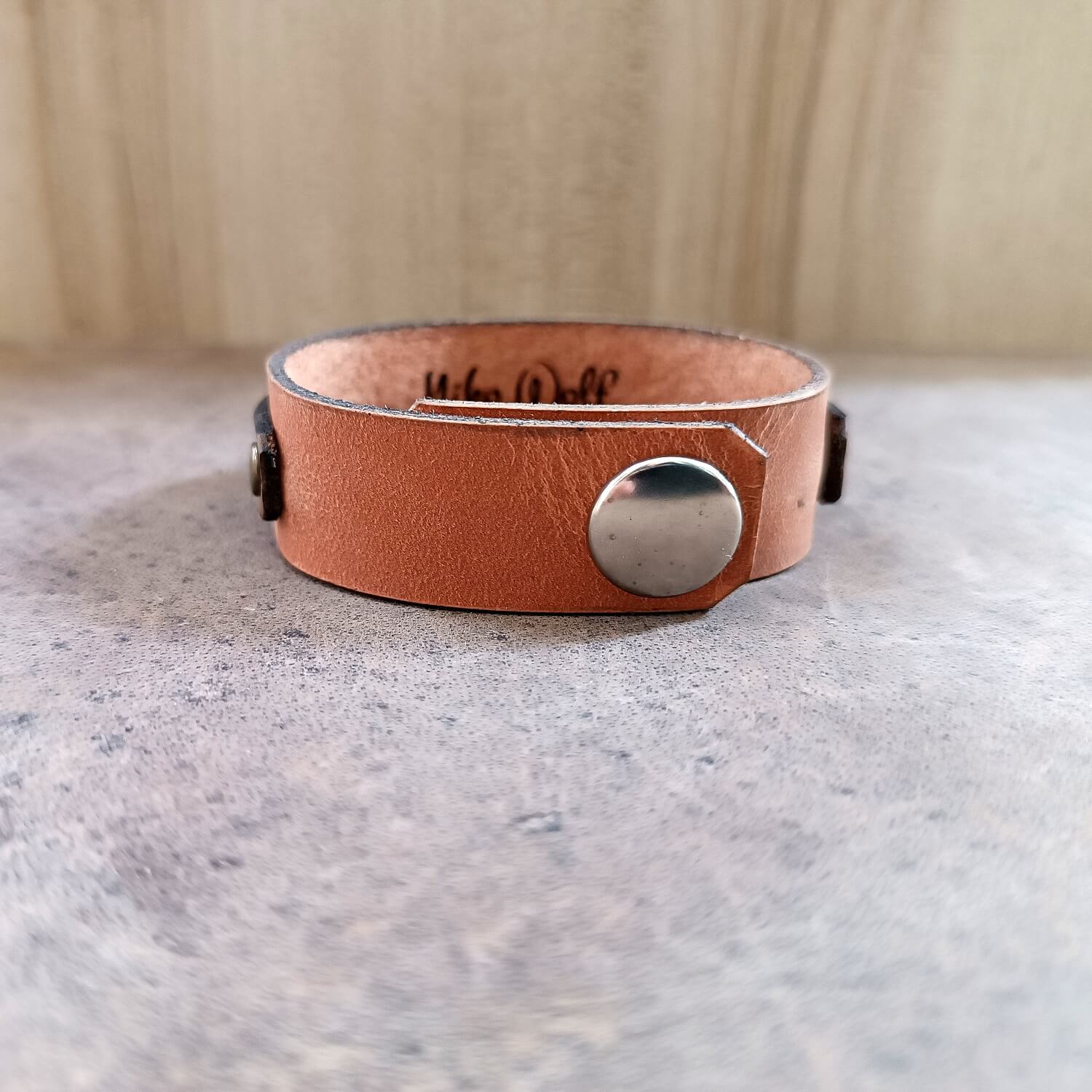 Brown Layered Leather Bracelet featuring a handcrafted brass wolf head pendant, backside view of closure and engraved underside area