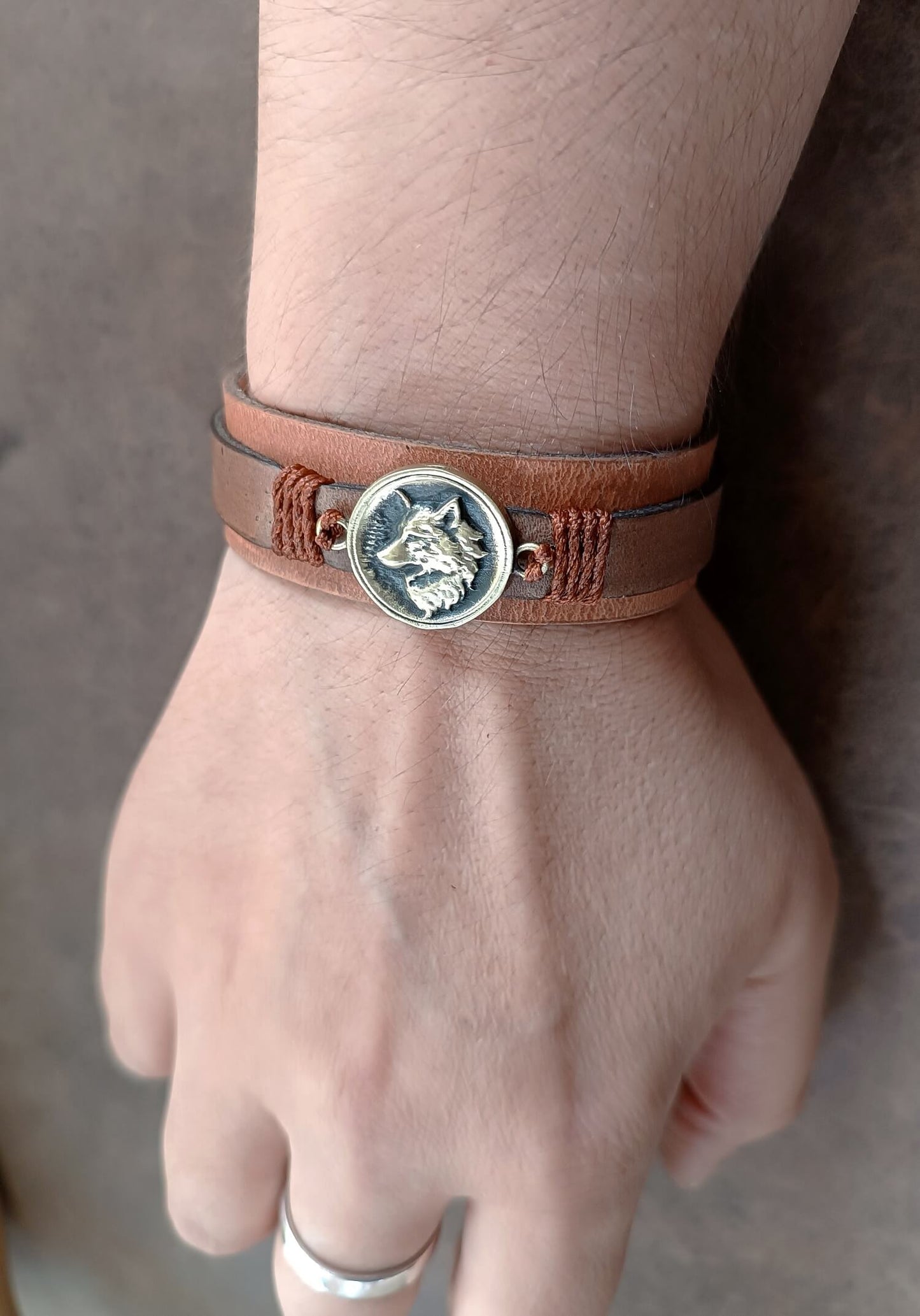 Brown Layered Leather Bracelet featuring a handcrafted brass wolf head pendant worn on wrist